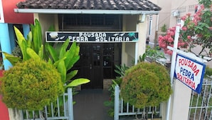 Un edificio con un cartel que dice 'Pousada Pedra Solitaria' en la entrada.