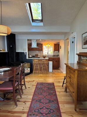Una cocina amplia con comedor, muebles de madera y tragaluz.