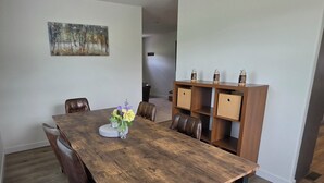 A dining area with a wooden table, chairs, a vase with flowers, and a cabinet with decorative items. - Beautiful 3-bedroom home in rural Mossyrock.  Close to recreational activities. (Mossyrock)