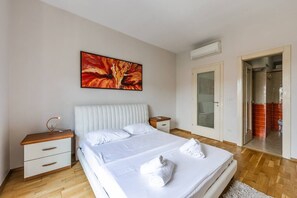 Ein Schlafzimmer mit Bett, Nachttisch und einem Bild an der Wand.
