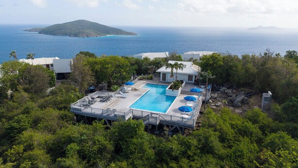 A pool area with a view of the ocean and a mountain in the distance. - Brand New Centrally Located  2BD/1BA Ocean View (St. Thomas)