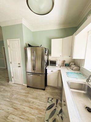 A kitchen with a stainless steel refrigerator, a microwave, and a sink. - Fully furnished 3BR / 2.5BA townhouse available for monthly stays. (Tybee Island)