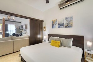 Ein Schlafzimmer mit einem großen Bett, einer Couch, einem Schreibtisch und einem Spiegel.