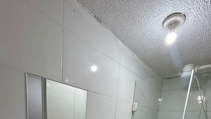 Un baño pequeño y funcional con lavabo, inodoro y ducha blancos.