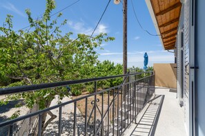 A balcony with a metal railing, a view of trees, and a building with a beige wall. - Apartment 'Anna's House B' with Mountain View, Wi-Fi and Air Conditioning (Chortata)