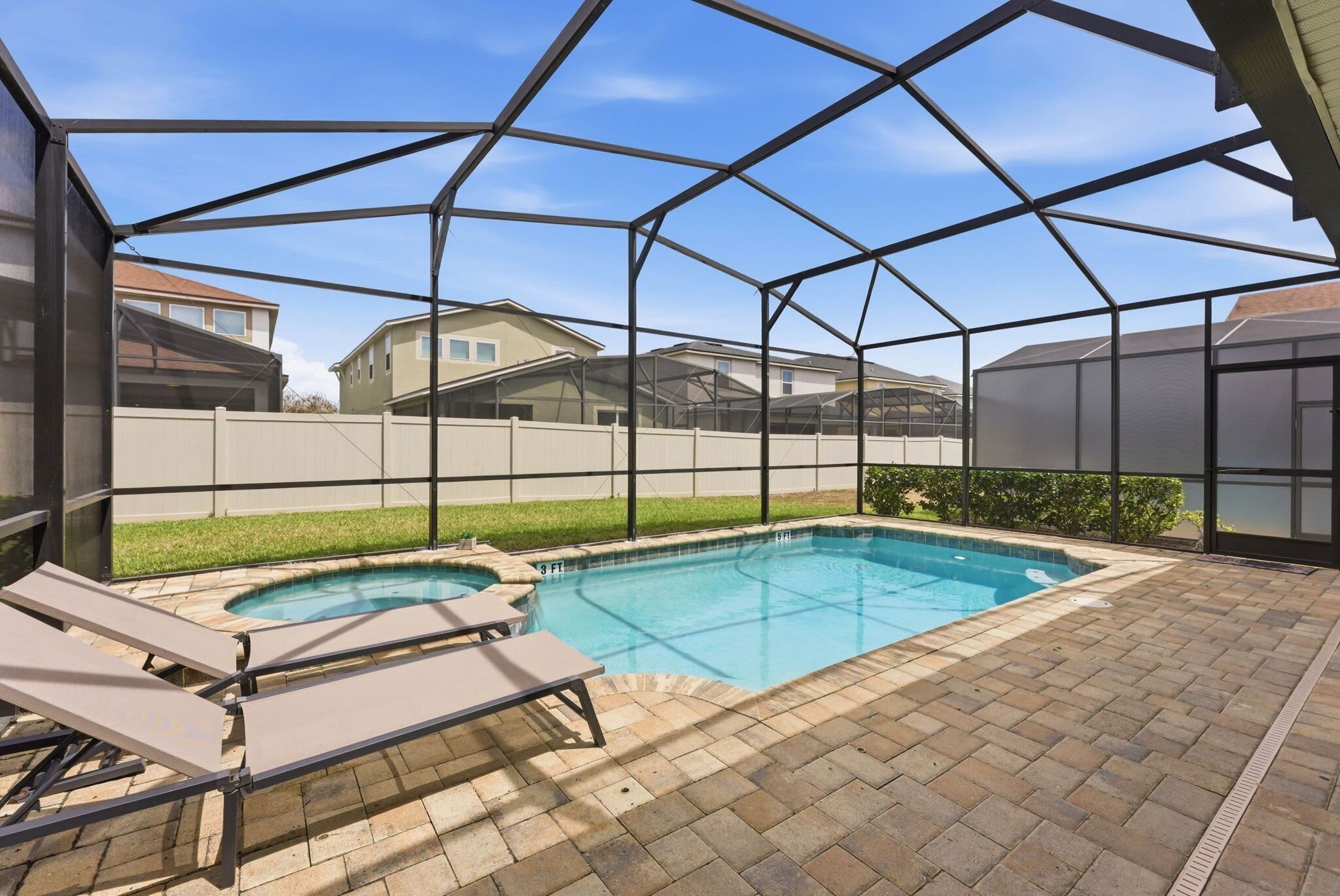 Un jardin avec une piscine, des chaises longues et un patio couvert.