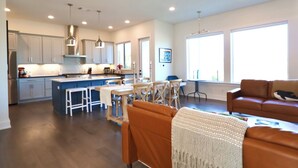 A spacious living area with a kitchen, dining table, and seating. - La-La-Lakeshore - Lake Front, Boat Dock & Launch (Spicewood)