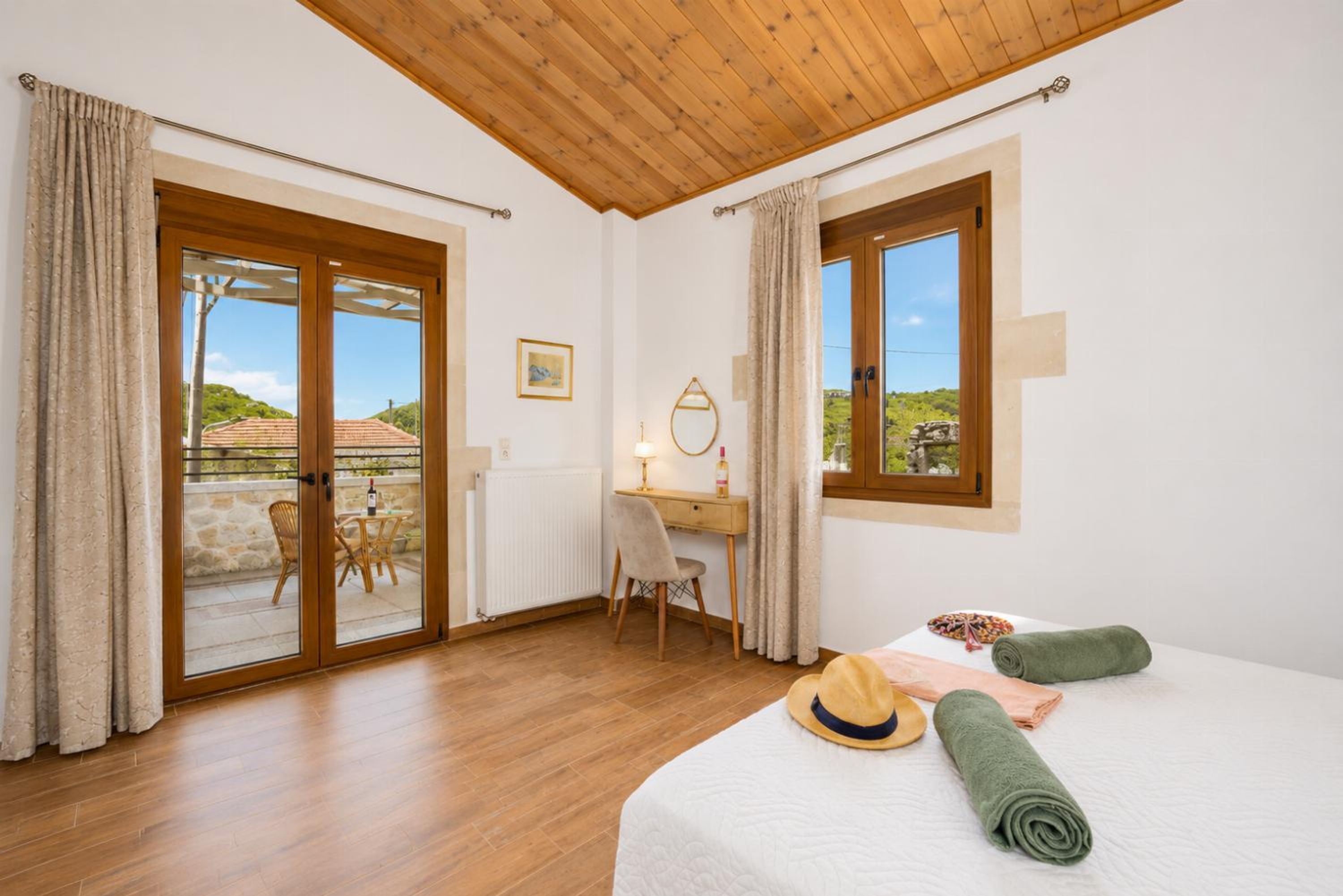 A bedroom with a bed, a desk, a chair, and a view through the window.