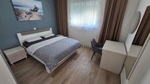 Una camera da letto moderna con un letto, comodini, una scrivania e una sedia.