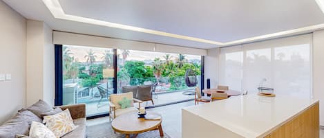 A modern living room with a sofa, a round coffee table, and a kitchen island.