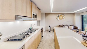 Une cuisine moderne avec des meubles en bois, un four à micro-ondes encastré et un îlot central doté d’un évier.