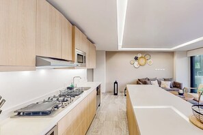 A modern kitchen with wooden cabinets, a built-in microwave, and a central island with a sink.