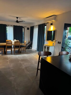 A modern kitchen with a built-in stove, a dining area with a table and chairs, and a ceiling fan.
