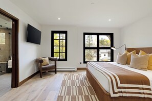 A bedroom with a bed, a chair, a TV, and two windows. - Modern Mountain Home with Lux Kitchen & Cozy Living Room Heart of Beaver Creek (Beaver Creek)