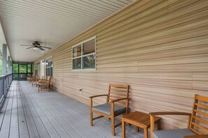 A covered porch with wooden chairs and a ceiling fan. - Spacious 4-Bedroom Cabin with Theater, Game Room, Fireplaces & Year-Round Views (Murphy)