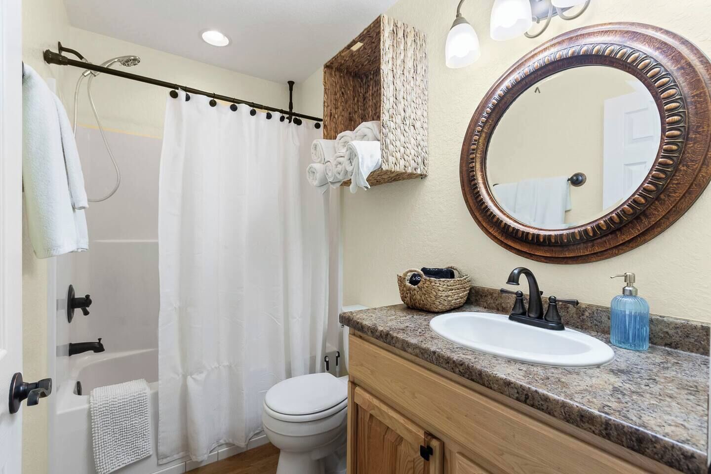 Une salle de bain équipée d’une douche, de toilettes, d’un lavabo et d’un miroir.