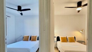 A hotel room with two beds, a ceiling fan, and a bedside lamp. - Arles apartment. Terrace overlooking garden, 2 bedrooms, 2 beds, living room, bathroom (Arles)