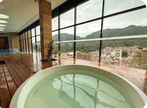 A large indoor swimming pool with a view of a cityscape and mountains. - Prime District 1302 (Bogotá)