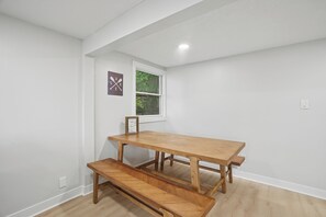 A room with a wooden table and bench, a window, and a wall-mounted picture. - Lakefront 2 bedroom house in Zimmerman on Elk Lake (Zimmerman)