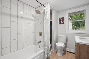 A bathroom with a shower, toilet, and window. - Lakefront 2 bedroom house in Zimmerman on Elk Lake (Zimmerman)