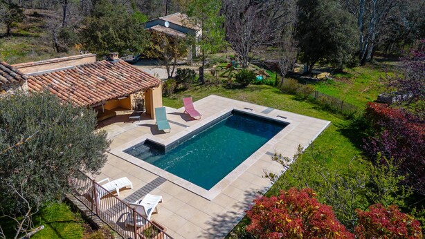 A swimming pool with lounge chairs, a patio area, and a view of a mountainous landscape. - House in Villars, in the ochre hills of the Luberon, Vaucluse (Villars)
