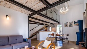 A modern interior with a staircase, a dining area, and a living room with a sofa and a coffee table. - House in Villars, in the ochre hills of the Luberon, Vaucluse (Villars)
