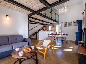 Ein modernes Interieur mit Treppe, Essbereich und Wohnzimmer inklusive Sofa und Couchtisch.
