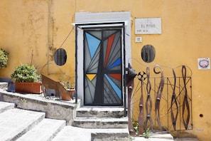 A building entrance with a geometric door design, a metal gate, and a sign indicating the address. - Spacious apartment in the heart of Petraio, one of Naples' most authentic neighborhoods, just a 10-minute walk from the Vanvitelli metro station and the Petraio funicular. Located in a 19th-century building, it retains vaulted ceilings, fine details and  (Napoli)