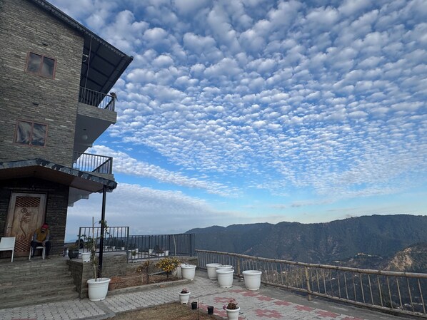 Ein Gebäude mit einem Balkon mit Blick auf eine gebirgige Landschaft.