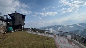 Un edificio moderno con un balcone affacciato su un paesaggio montuoso.
