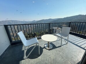 A balcony with two white chairs and a small round table, overlooking a mountainous landscape. - Ivaan Belle-Vue (Dhari)