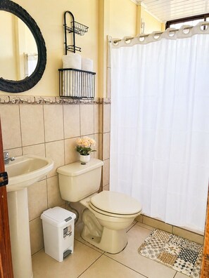 A bathroom with a toilet, sink, and shower curtain. - Starlink Jungle Retreat | Eco Living + Fast WiFi (Cahuita)
