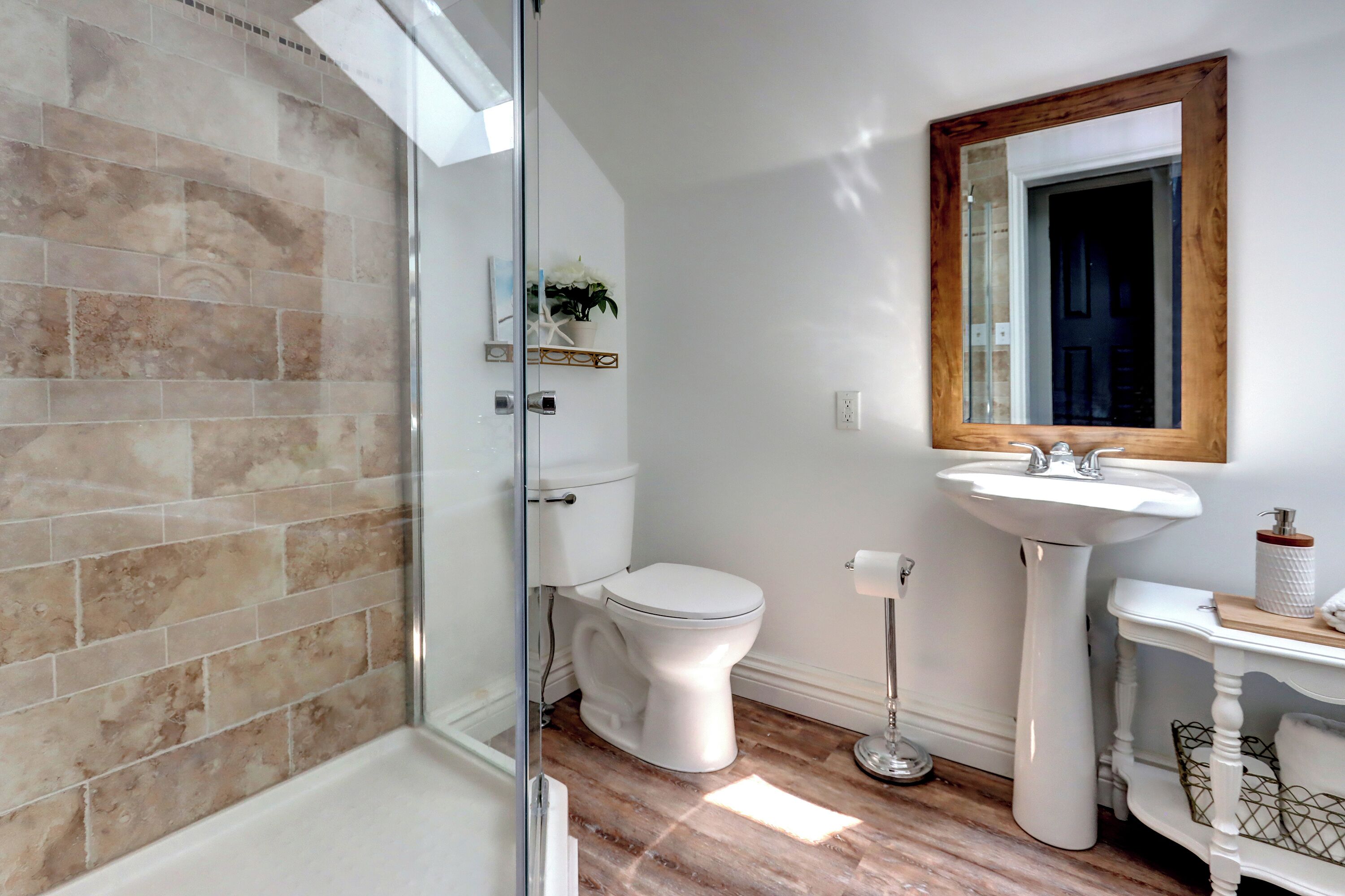 Un bagno con doccia, servizi igienici, lavandino e specchio.