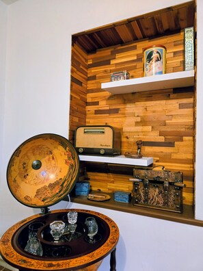 A wooden wall with a radio, a vintage radio, and a small shelf with a framed picture and a sign.
