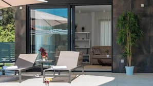 A modern outdoor lounge area with a hot tub, two lounge chairs, and a potted plant. - Villa Blue Diamond (Biograd)