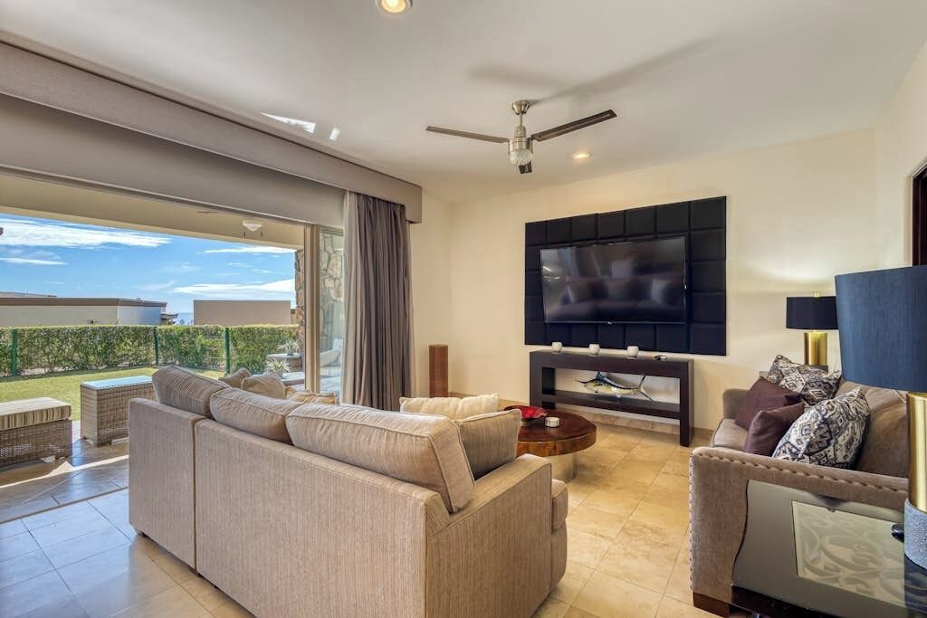 A modern living room with a sofa, a coffee table, and a TV.