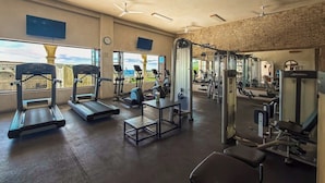 Een fitnessruimte met loopbanden, krachtherinneringen en uitzicht op het buiten.