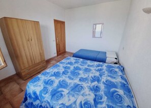 Une chambre à coucher avec un lit, une armoire et une fenêtre.
