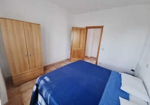 Une chambre à coucher avec un lit, une armoire et une porte.