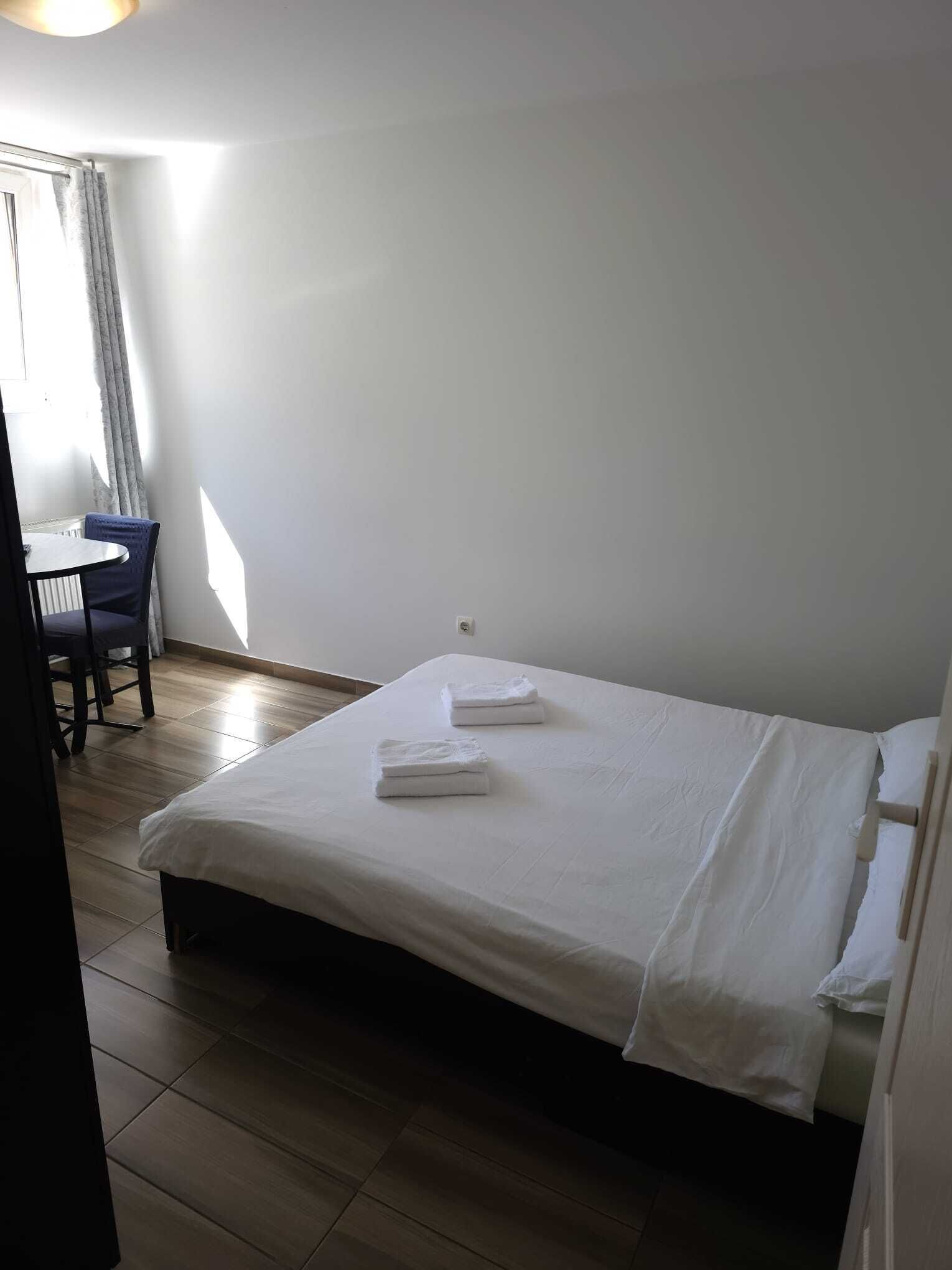 A room with a bed, a chair, and a small table.
