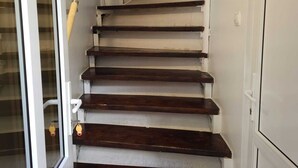 A staircase with wooden steps and a glass door on the left. - Vivaldi Studios (Cluj-Napoca)