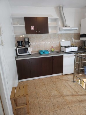 A kitchen with a microwave, coffee maker, stove, and cabinets. - Vivaldi Studios (Cluj-Napoca)