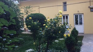 A yellow building with a red roof, a white door, and a small window. - Vivaldi Studios (Cluj-Napoca)