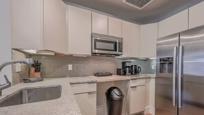 A modern kitchen with a stainless steel refrigerator, a microwave, and a coffee maker. - Spacious 1bed/1bath in Back Bay (Boston)