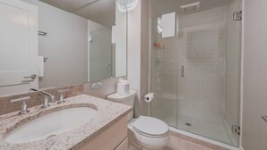 A bathroom with a sink, toilet, and glass shower enclosure. - Spacious 1bed/1bath in Back Bay (Boston)
