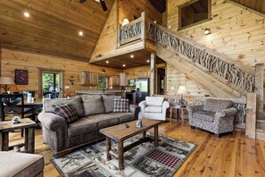 A wooden cabin interior with a sofa, armchairs, a staircase, and a kitchen area. - Mtn Cabin w/ Hot Tub • Game Room • Grill • Views (Blue Ridge)