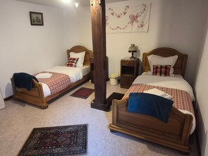 Two wooden beds with checkered bedding, a nightstand with a lamp, a small rug, and a wall hanging. - Holiday Home 'Voyage En Alsace Chez Gaby' with Wi-Fi (Hunawihr)