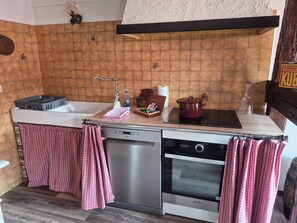 Una cocina compacta con lavavajillas, horno y una pequeña encimera.