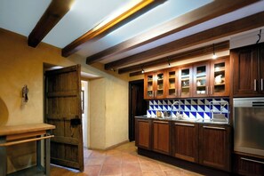 Eine Küche mit Holzausstattung, einem Edelstahlkühlschrank und einer gefliesten Spritzwand.