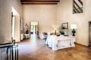 A spacious room with a fireplace, a dining table, and a sofa.